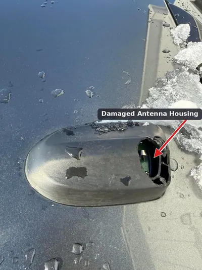 A sun-damaged and cracked roof antenna base on a Toyota Prius.