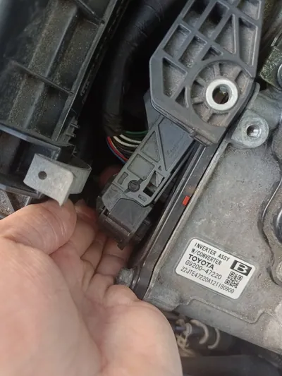 Complex wiring harness routing in the engine bay of a 2023-2025 Toyota Prius.