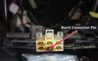 A melted and water-damaged automotive electrical connector showing signs of a short circuit.