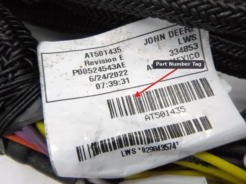 An OEM automotive wiring harness laid out, displaying its part number identification tag.