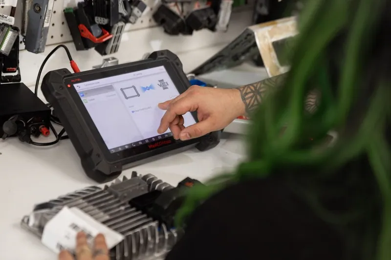 A technician using an advanced diagnostic tool like an Autel MaxiIM to program a vehicle's immobilizer system.