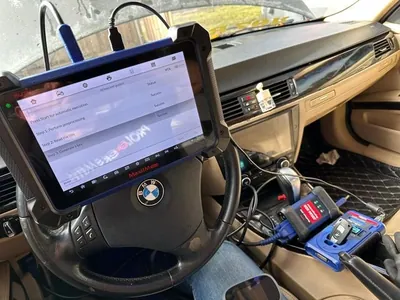 An automotive locksmith or technician using an advanced diagnostic tablet to program a vehicle's immobilizer system.