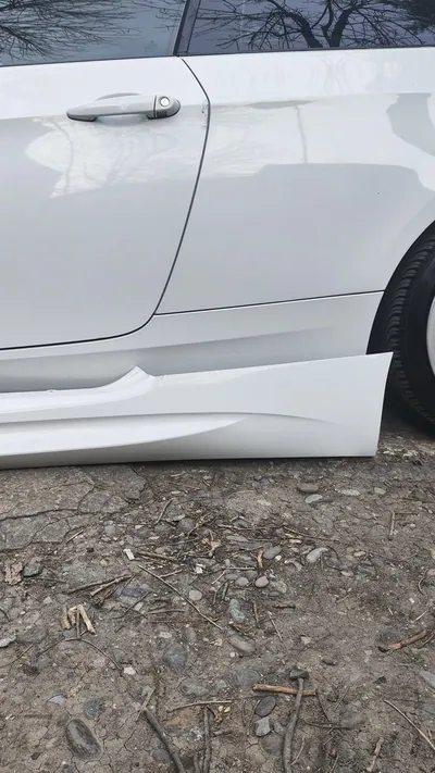A brand new, unpainted black plastic rocker panel replacement part.