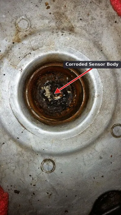 A heavily corroded knock sensor located in the engine valley under the intake manifold. <a href=