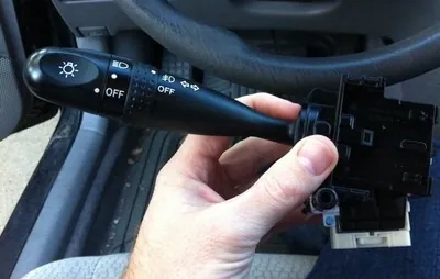 A steering column multifunction switch assembly removed from a vehicle, showing the electrical connector.