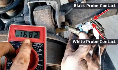 A mechanic using a digital multimeter to test the electrical pins on a wheel speed sensor connector.