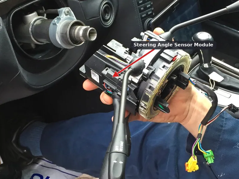 A steering angle sensor and clock spring assembly removed from a vehicle's steering column.