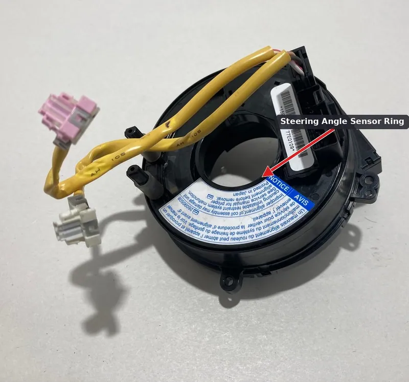 A steering angle sensor mounted behind the steering wheel hub, or a yaw rate sensor located under the center console.