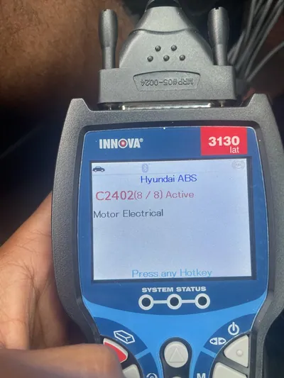 An OBD2 diagnostic scanner displaying the C2402 trouble code for a motor electrical circuit failure.