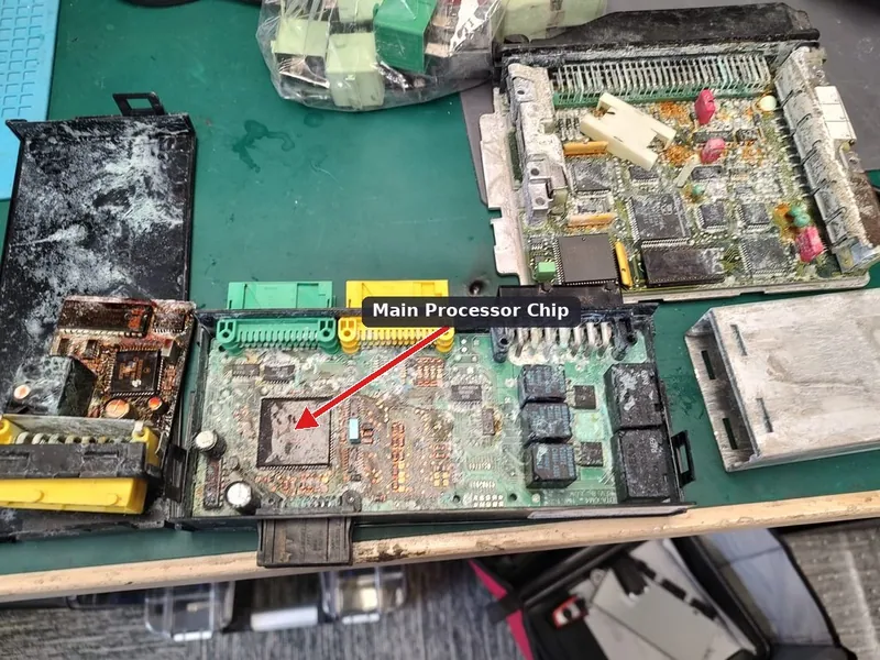 An exposed Engine Control Module circuit board showing the internal memory chips and circuitry.