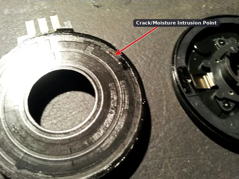 A damaged transfer case encoder ring with a cracked plastic housing and internal moisture damage.