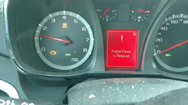 A dashboard displaying a Check Engine Light and a Reduced Engine Power warning message.