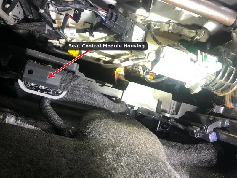 A power seat control module located under the driver's seat of a vehicle.