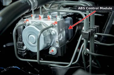 An Anti-lock Brake System (ABS) module and pump assembly located in a vehicle's engine bay.