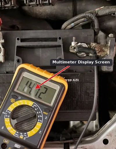 Mechanic using a digital multimeter to test the voltage across a car battery's terminals