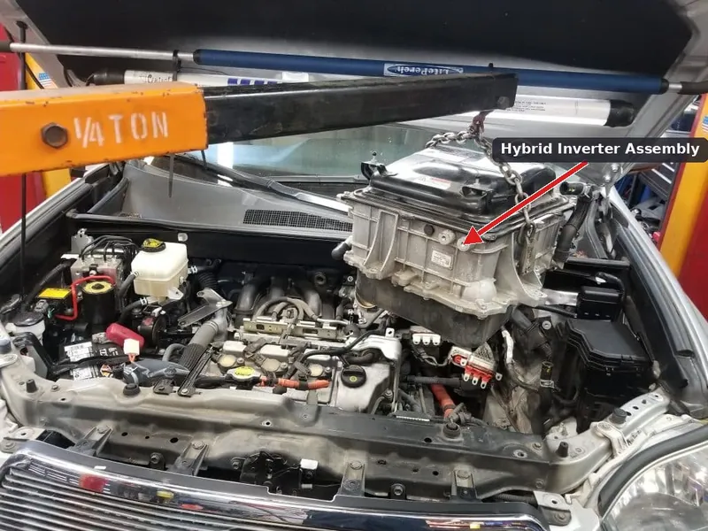 The power converter, or inverter, located in the engine bay of a 2007-2011 Toyota Camry Hybrid.