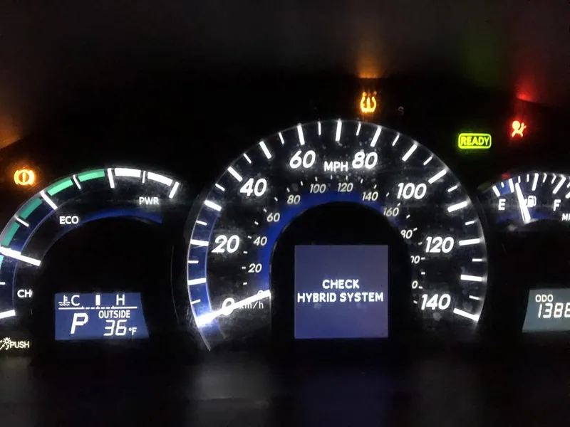 A 'Check Hybrid System' warning message displayed on a Toyota Camry dashboard.