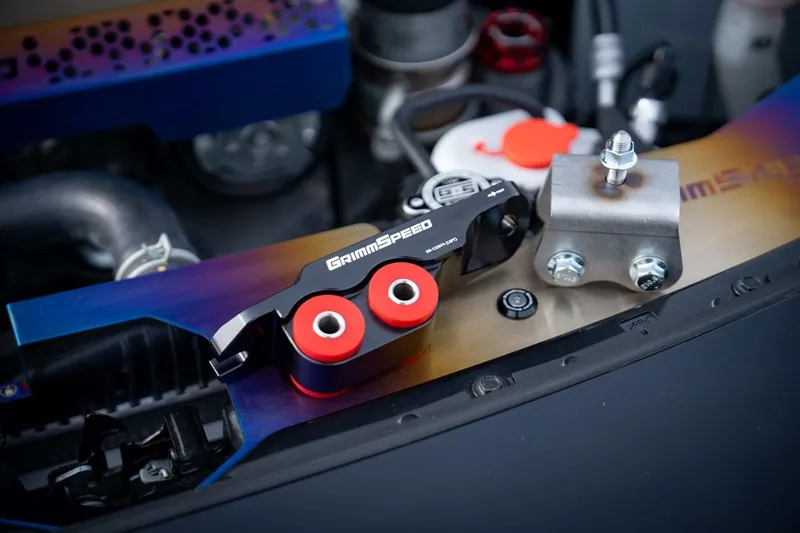 A set of red polyurethane engine mount inserts used for performance upgrades.