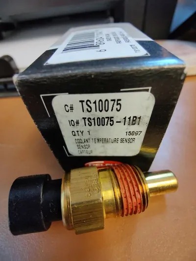 A high-quality aftermarket engine coolant temperature sensor in its retail packaging.